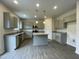 Well-lit kitchen featuring gray cabinets, granite countertops, stainless steel appliances, and an island at 158 Citizens Ct # 32, Four Oaks, NC 27524