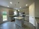 Well-lit kitchen featuring gray cabinets, granite countertops, stainless steel appliances, and an island at 158 Citizens Ct # 32, Four Oaks, NC 27524