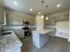 Well-lit kitchen featuring gray cabinets, granite countertops, stainless steel appliances, and an island at 158 Citizens Ct # 32, Four Oaks, NC 27524