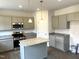 New kitchen with stainless appliances, granite countertops, an island, and gray cabinetry at 158 Citizens Ct # 32, Four Oaks, NC 27524