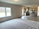 Bright, open-concept living room featuring a large window and modern kitchen in background at 158 Citizens Ct # 32, Four Oaks, NC 27524