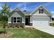 Charming single-story home featuring a manicured lawn, two-car garage, and inviting craftsman-style facade at 346 Olivia Crossing Ct # 12, Four Oaks, NC 27524