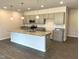 Open kitchen with gray cabinets, a granite island, stainless appliances and modern pendant lighting at 346 Olivia Crossing Ct # 12, Four Oaks, NC 27524