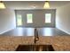 Open-concept living space with kitchen island, stainless steel faucet, and durable hard surface floors at 346 Olivia Crossing Ct # 12, Four Oaks, NC 27524