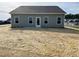 Rear view of a single-story home with a gray exterior and a large backyard at 346 Olivia Crossing Ct # 12, Four Oaks, NC 27524