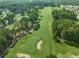 Aerial view of a lush green golf course with trees and sand bunkers at 490 Barbour Farm Ln, Four Oaks, NC 27524