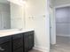 Bathroom featuring dual sinks, dark wood cabinets, a large mirror, and modern fixtures, with a walk-in closet view at 490 Barbour Farm Ln, Four Oaks, NC 27524