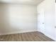 Bright, empty bedroom featuring hardwood floors, neutral walls, and a door, ready for customization at 490 Barbour Farm Ln, Four Oaks, NC 27524