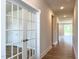 Hallway view with hardwood floors, glass-paneled doors, and modern lighting, leading to spacious rooms at 490 Barbour Farm Ln, Four Oaks, NC 27524