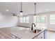 Spacious kitchen with a large granite island, pendant lighting, and adjacent screened porch at 490 Barbour Farm Ln, Four Oaks, NC 27524