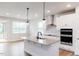 Modern kitchen with granite countertops, sleek black faucet, stainless appliances, and wood-look flooring at 490 Barbour Farm Ln, Four Oaks, NC 27524