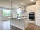 Bright, modern kitchen featuring white cabinets, stainless steel appliances, and a stylish island with granite countertops at 490 Barbour Farm Ln, Four Oaks, NC 27524