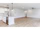 Bright kitchen with a granite island, stainless steel dishwasher, and wood flooring extending to living area at 490 Barbour Farm Ln, Four Oaks, NC 27524