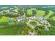 Aerial view of community amenities featuring a roundabout, pool, tennis courts, and golf course at 736 Golfers View Vw, Pittsboro, NC 27312