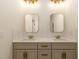 Elegant bathroom featuring double sinks with gold fixtures and a well lit mirror at 736 Golfers View Vw, Pittsboro, NC 27312
