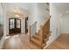 Bright foyer featuring hardwood floors, a chandelier, and a staircase with black iron spindles at 736 Golfers View Vw, Pittsboro, NC 27312