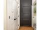 Hallway with white doors, black hardware, and a view into a light-filled laundry room at 736 Golfers View Vw, Pittsboro, NC 27312