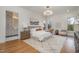 Main bedroom boasts a chandelier, hardwood floors, and serene views of the yard at 736 Golfers View Vw, Pittsboro, NC 27312