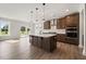 This is a kitchen with a center island, modern appliances, dark cabinets and light hardwood style flooring at 1224 Cricket St, Elon, NC 27244