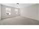 Bedroom featuring neutral carpet, white walls, and two windows that look out to the neighborhood at 1228 Cricket St, Elon, NC 27244