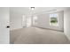 Spacious bedroom with tray ceiling, two large windows, and neutral carpet at 1228 Cricket St, Elon, NC 27244