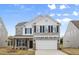 Charming two-story home featuring a stone facade, black shutters, and a two-car garage at 1228 Cricket St, Elon, NC 27244