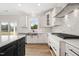 Modern kitchen with stainless steel appliances, white cabinets, and a large window at 1228 Cricket St, Elon, NC 27244