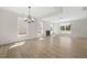 Bright living room with wood floors, fireplace, large windows, and modern chandelier at 1228 Cricket St, Elon, NC 27244