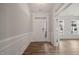 Bright entryway with hardwood floors, wainscoting, and a view of a nearby room at 1232 Cricket St, Elon, NC 27244