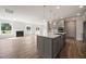 Open-concept kitchen featuring an island, stainless steel appliances, and a fireplace at 1232 Cricket St, Elon, NC 27244