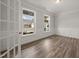 Office with wood floors, wainscoting, large windows, and glass French doors at 1232 Cricket St, Elon, NC 27244