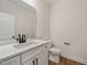 This powder bathroom boasts a white vanity and dark bronze hardware at 1301 Cricket St, Elon, NC 27244