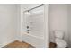 Bathroom with a white shower-tub combo, a small window and a white toilet at 1301 Cricket St, Elon, NC 27244
