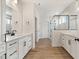 Bright bathroom featuring dual vanities, a glass-enclosed shower, and stylish fixtures at 1301 Cricket St, Elon, NC 27244