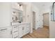 Bright bathroom featuring a vanity with double sinks, a large mirror, and a glass-enclosed shower at 1301 Cricket St, Elon, NC 27244
