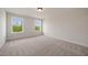 Sunny bedroom featuring neutral walls and carpet with a view of the trees outside at 1301 Cricket St, Elon, NC 27244