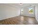 A bright bedroom with hardwood floors and two windows overlooking the outdoor landscape at 1301 Cricket St, Elon, NC 27244