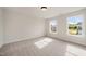 Sunlit bedroom with neutral walls, carpet, and dual windows offer views of the neighborhood at 1301 Cricket St, Elon, NC 27244