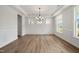 Bright dining room featuring hardwood floors, decorative molding, and contemporary chandelier at 1301 Cricket St, Elon, NC 27244