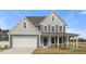 Charming two-story home featuring a two car garage, well-manicured lawn, and covered front porch at 1301 Cricket St, Elon, NC 27244