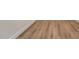 Close-up of new hardwood-style flooring with neutral wall and white trim at 1301 Cricket St, Elon, NC 27244