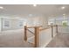 Open second floor hallway overlooking the main level with carpeted floors and white wooden railings at 1301 Cricket St, Elon, NC 27244
