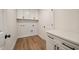 This laundry room boasts wood-look flooring and white shaker cabinetry at 1301 Cricket St, Elon, NC 27244
