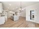 Open concept living area with hardwood floors, kitchen and adjacent room at 1301 Cricket St, Elon, NC 27244