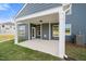 Covered patio with white pillars, gray siding, and an exterior door to the backyard at 1301 Cricket St, Elon, NC 27244