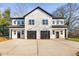 Modern duplex with white siding, black garage doors, and ample parking at 329 & 331 Roxboro St, Haw River, NC 27258
