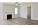 Living room with wood floors, a fireplace, and a ceiling fan at 59 Mossy Bridge Ct, Lillington, NC 27546