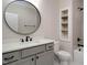 Modern bathroom features gray vanity, round mirror, tiled shower with black hardware, and built-in shelves at 70 Water Willow Ln, Zebulon, NC 27597