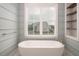 A bright bathroom features a freestanding tub under a large window and custom shelving at 70 Water Willow Ln, Zebulon, NC 27597