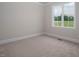 Bright bedroom with neutral carpet and paint features a large window with a view at 70 Water Willow Ln, Zebulon, NC 27597